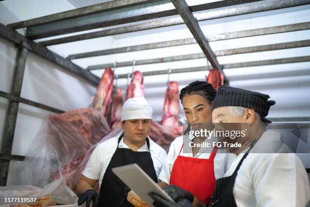 slagers analyseren vlees in een vlees locker - koelkast stockfoto's en -beelden