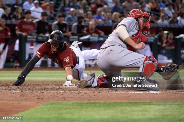 Nick Ahmed of the Arizona Diamondbacks safely slides home against Matt Wieters of the St. Louis Cardinals in the sixth inning of the MLB game at...