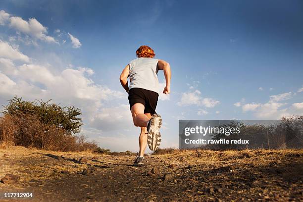 redhead running in the countryside - chemin de terre photos et images de collection