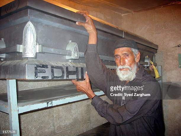 Volunteer of the private humanitarian organization, Edhi Welfare Trust, shows the coffin containing the alleged remains of U.S. Journalist Daniel...