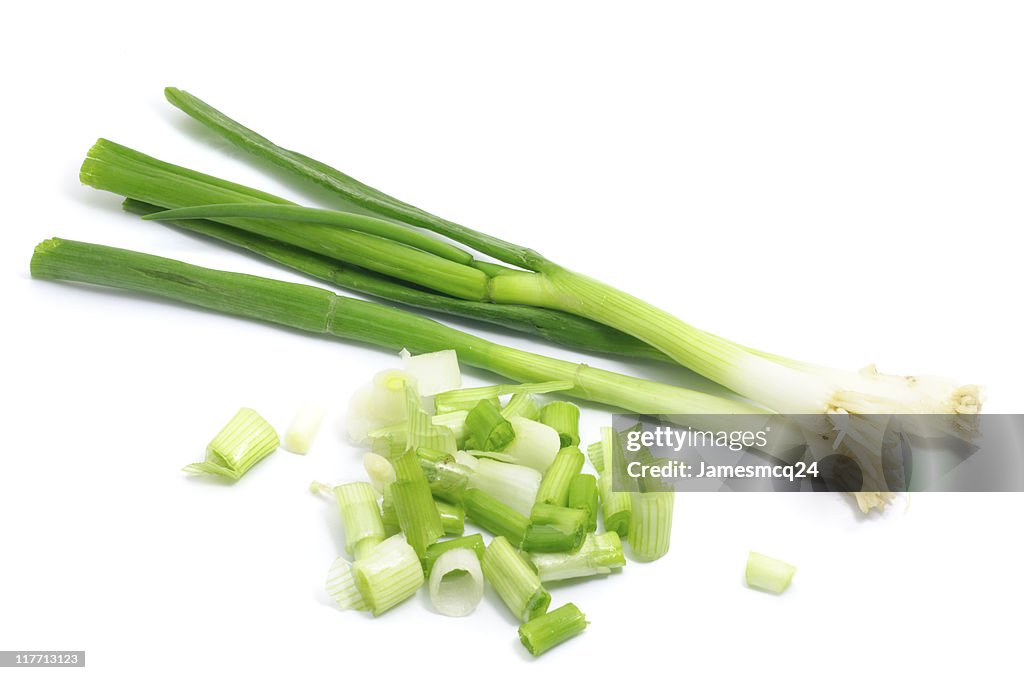 Whole and chopped green onions isolated on white background