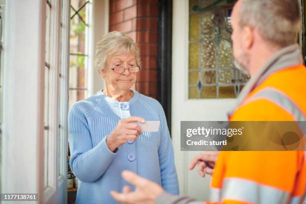 checking the tradesman's credentials - door to door salesperson stock pictures, royalty-free photos & images