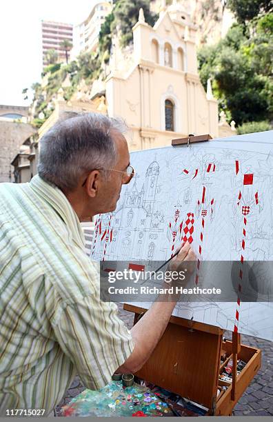 An artist works on a painting outside Sainte Devote church ahead of the Royal Wedding of Prince Albert II of Monaco to Charlene Wittstock on June 30,...