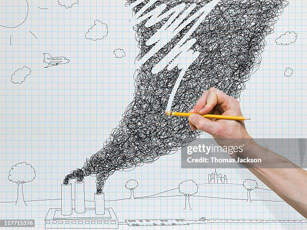 Hand holding pencil erasing pollution