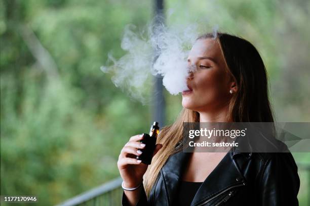 primer plano de la mujer fumando cigarrillo electrónico - vaping fotografías e imágenes de stock