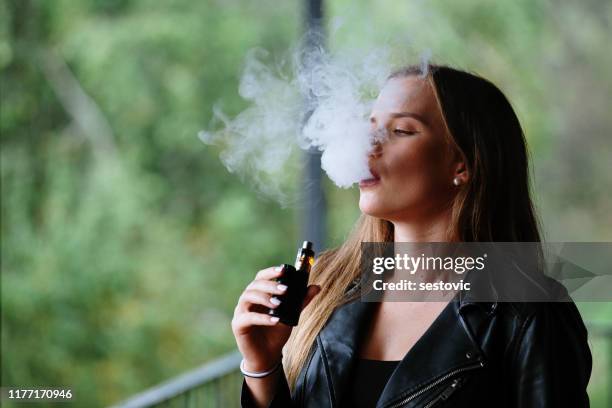 closeup of woman smoking electronic cigarette - vaping imagens e fotografias de stock