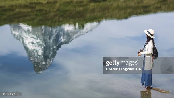 young woman standing on the lake with reflection of famous matterhorn, alps, switzerland - lakeshore stockfoto's en -beelden