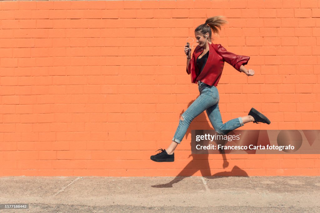 Happy young woman running to school