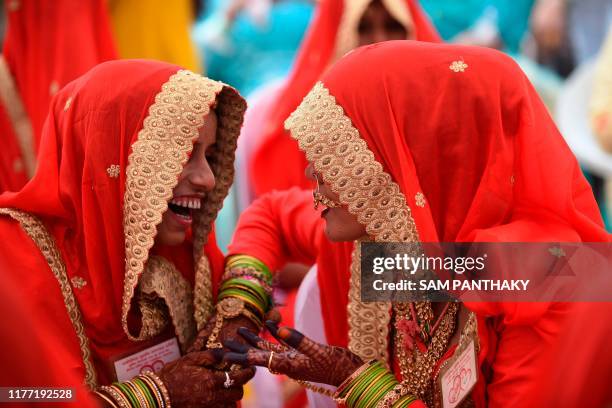 Muslim brides share a light moment during a mass wedding of 35 couples in Ahmedabad on October 20, 2019.
