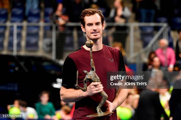 Britain's Andy Murray celebrates with the trophy after winning against Switzerland's Stanislas Wawrinka in their men's single tennis final match of...