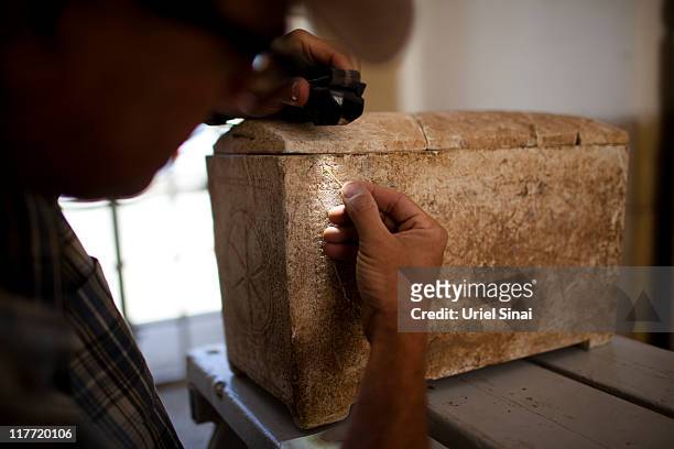 Doctor Boaz Zissu of the Bar Ilan University shows the inscription on a 2,000-year-old ossuary at the Rockefeller Museum on June 30, 2011 in...