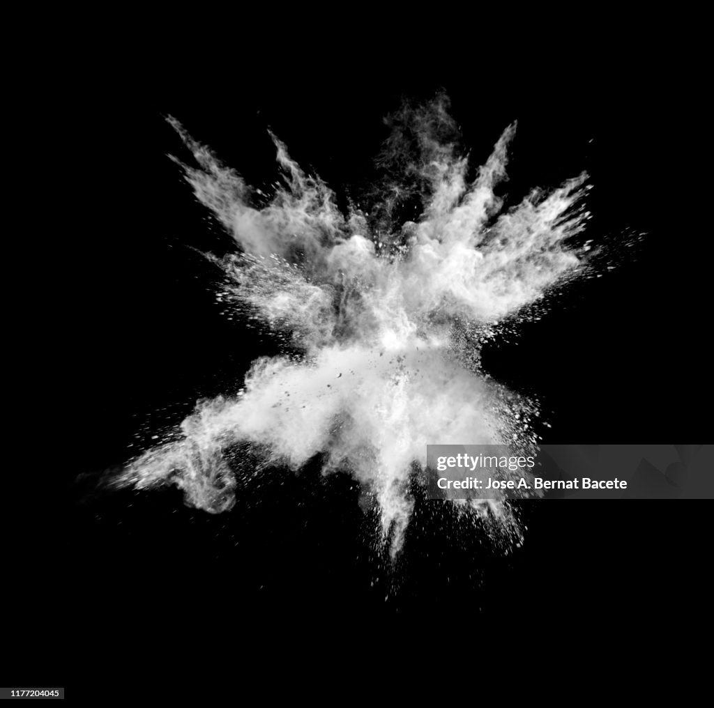 Explosion by an impact of a cloud of particles of powder of white color on a black background.