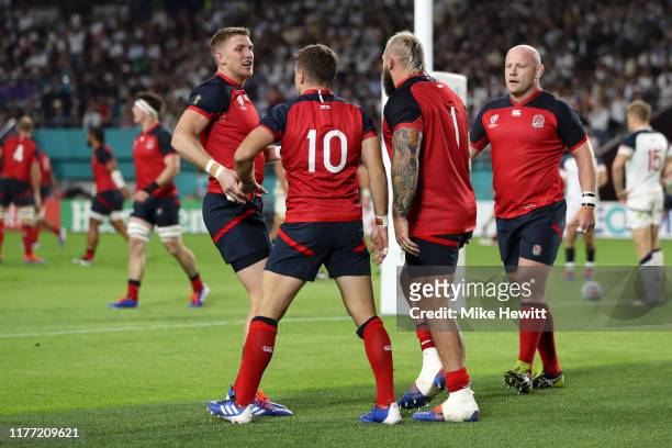 George Ford of England celebrates with teammates Ruaridh McConnochie, Joe Marler and Dan Cole after scoring his team's first try during the Rugby...