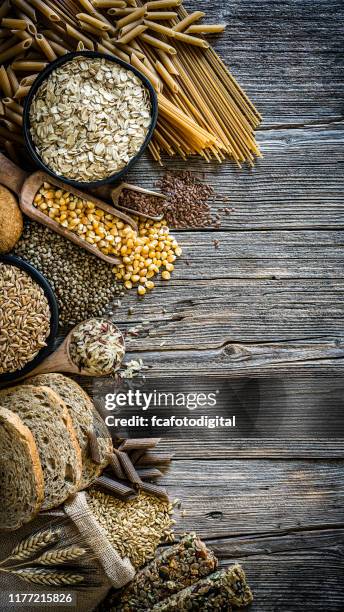 dietary fiber food backgrounds: wholegrain food border on rustic wooden table - wholegrain stock pictures, royalty-free photos & images