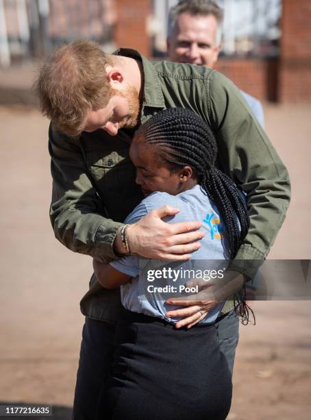 Prince Harry, Duke of Sussex is greeted by Tlotlo Moilwa during a visit to the Kasane Health Post, run by the Sentebale charity, on September 26,...