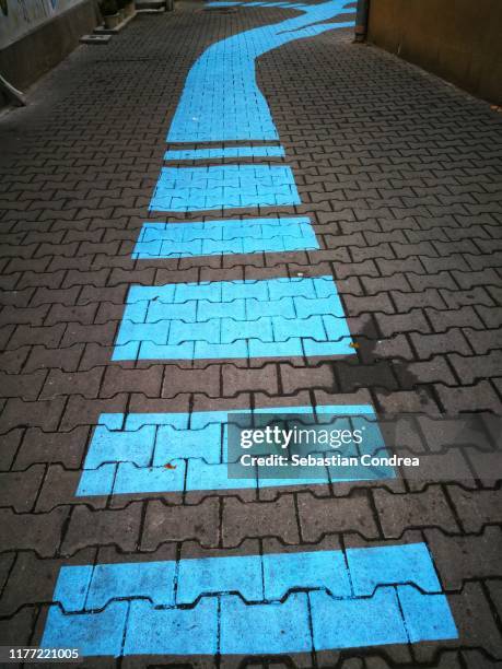 blue traffic arrow signage on the road. - following arrows stock pictures, royalty-free photos & images