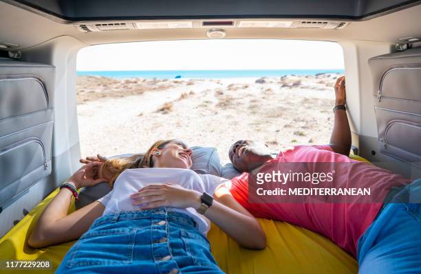 couple young multi ethnic lying in camper van - ex boyfriend stock pictures, royalty-free photos & images