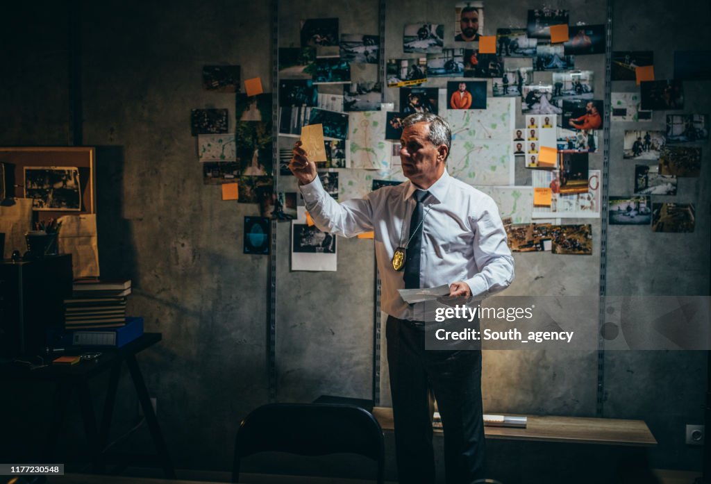Mature detective working late in office