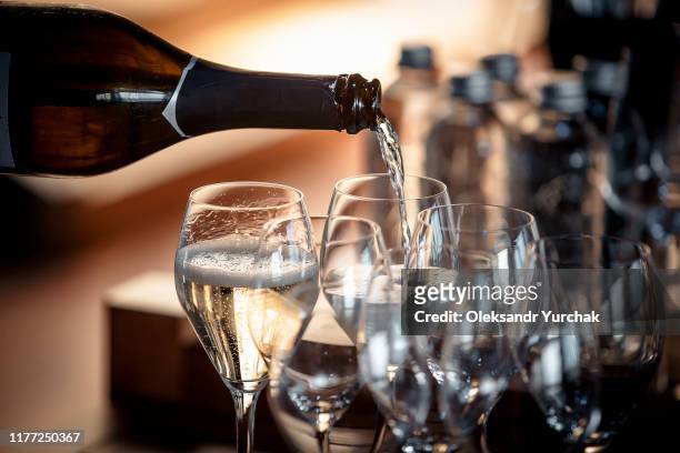sparkling wine is poured into a glass at a party - elegant cocktail party stockfoto's en -beelden