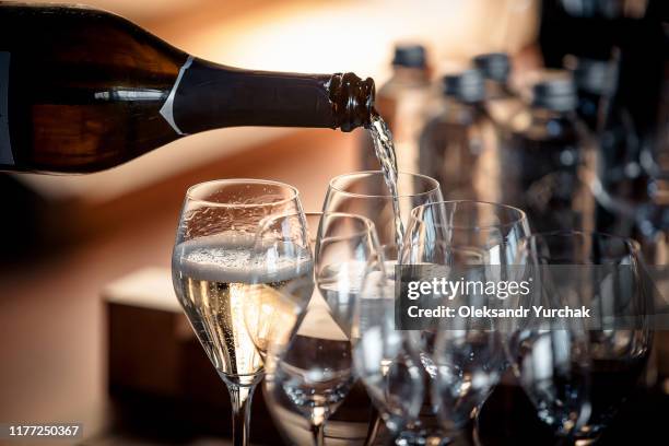 sparkling wine is poured into a glass at a party - elegant cocktail party stock pictures, royalty-free photos & images