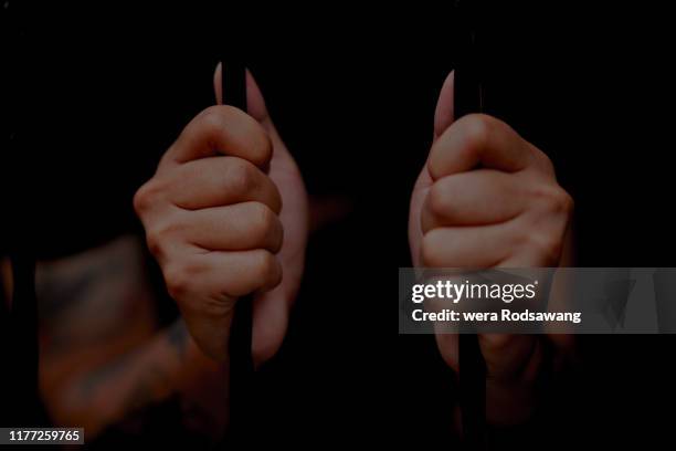 selective focus on palm hand of inmates being stuck in jail isolated over black background - fuzzy handcuffs stock pictures, royalty-free photos & images