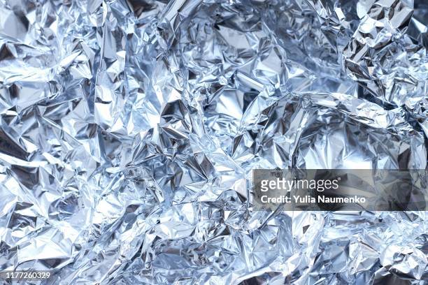 abstract crumpled silver aluminum foil, close up background texture. - platinum stock pictures, royalty-free photos & images