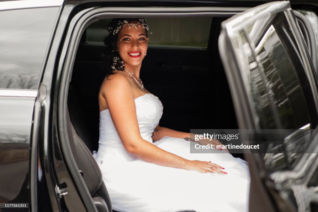 Millennial woman getting in limousine for her wedding.