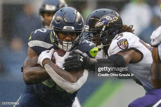 Running back Chris Carson of the Seattle Seahawks rushes against linebacker Josh Bynes of the Baltimore Ravens at CenturyLink Field on October 20,...