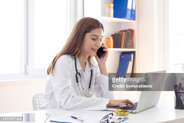 female doctor talking on phone - doctor laptop stock pictures, royalty-free photos & images