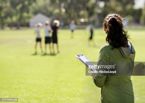 coach monitoring the team practicing - teaching assistant stock pictures, royalty-free photos & images