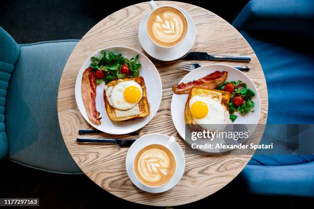 breakfast with croque madame and coffee served for two people in a cafe, high angle view - cafe symmetry stock pictures, royalty-free photos & images