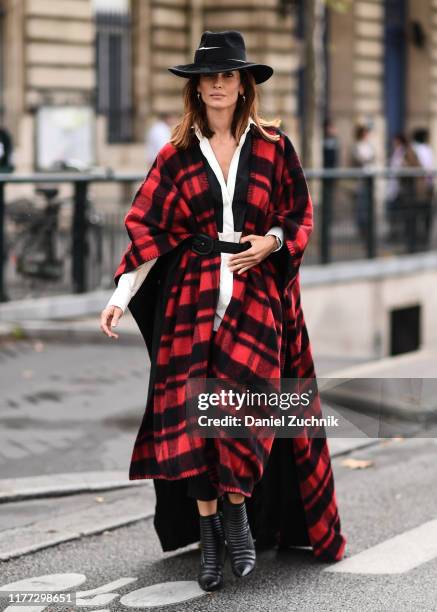 Guest is seen wearing a red and black flannel coat and a black hat outside the Redemption show during Paris Fashion Week SS20 on September 26, 2019...