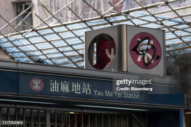 The MTR Corp. Logo sits damaged atop an entrance to the shuttered Yau Ma Tai station during protest in Hong Kong, China, on Sunday, Oct. 20, 2019....