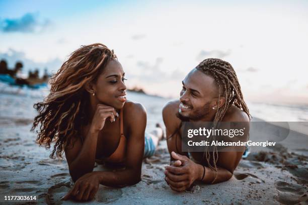 cute african couple lying down at the beach - cuba travel stock pictures, royalty-free photos & images