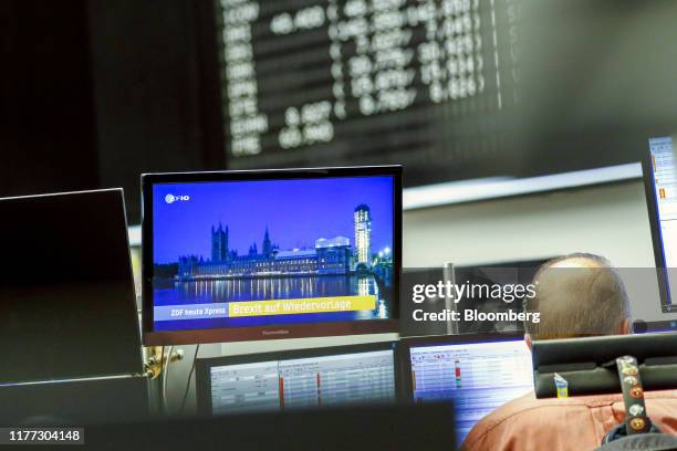 Screen displays a television news report on Brexit as a trader monitors financial data inside the Frankfurt Stock Exchange, operated by Deutsche...