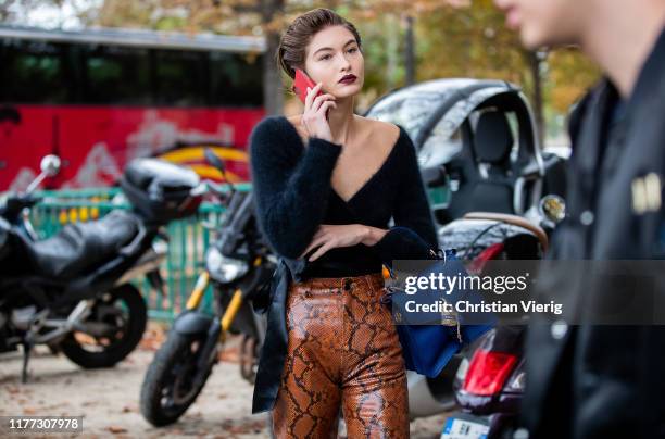 Model Grace Elizabeth is seen wearing blue Chloe bag, pants with snake print, navy cashmere v neck knit outside Chloe during Paris Fashion Week...