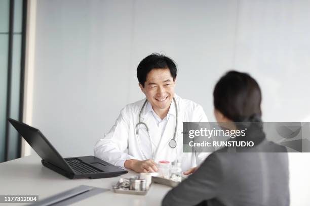 doctor talking to patient in clinic office - appointment ストックフォトと画像