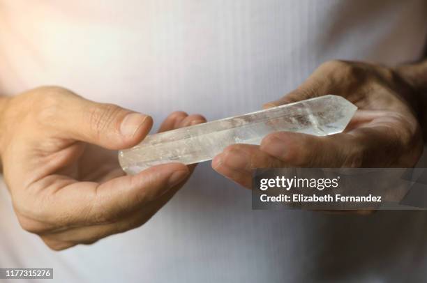 man's hands holding quartz crystal - clear quartz stock pictures, royalty-free photos & images