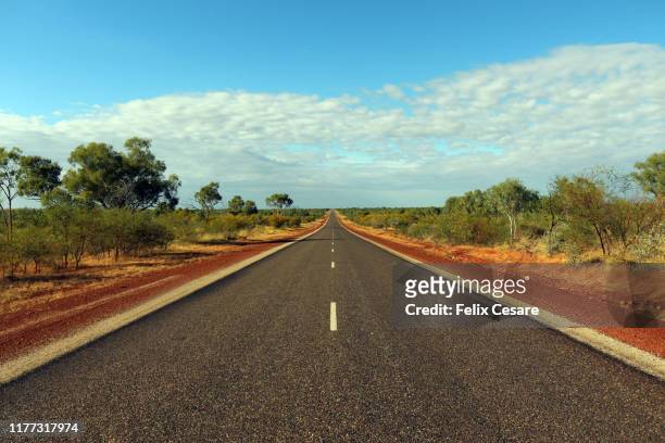 australian outback red roads - australia road stock-fotos und bilder