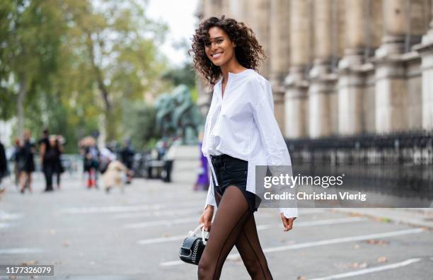 Cindy Bruna is seen wearing sheer tights, black shorts, white button shirt outside Redemption during Paris Fashion Week Womenswear Spring Summer 2020...