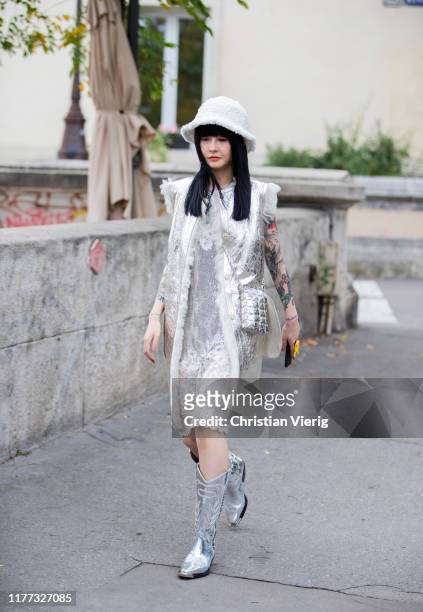 Guest is seen wearing bucket hat, silver coat, bag, cowboy boots outside Paco Rabanne during Paris Fashion Week Womenswear Spring Summer 2020 on...