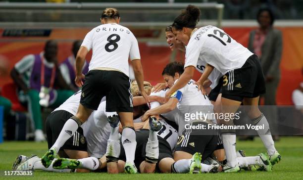 The team of Germany celebrates after Simone Laudehr scores her team's first goal during the FIFA Women's World Cup 2011 Group A match between Germany...