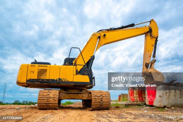 heavy duty construction equipment parked at worksite - excavator bucket stock pictures, royalty-free photos & images