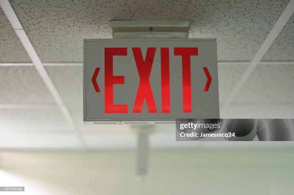 An exit sign hanging from a ceiling
