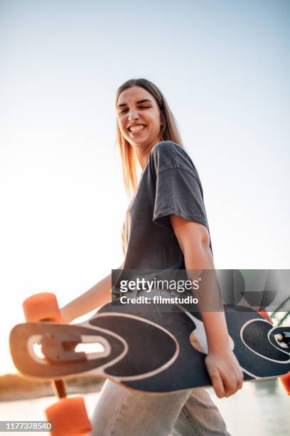 junge frau geht in den skatepark - woman longboard stock-fotos und bilder