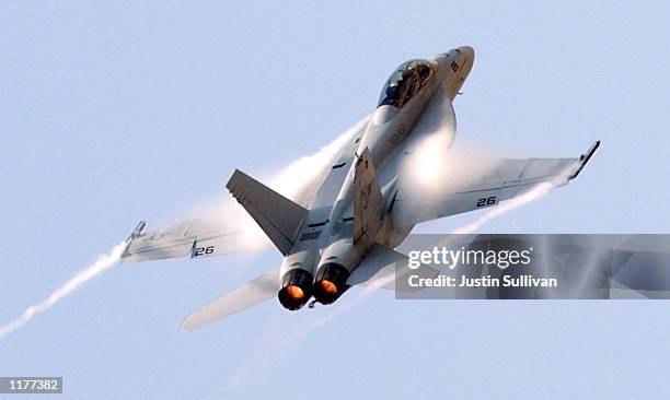 Condensation comes off the wings of a U.S. Navy F-18 Super Hornet as it accelerates during the 2002 Air Expo July 27, 2002 at Moffett Field in...