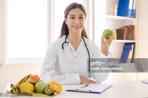 vrouwelijke diëtist tonen - nutritionist stockfoto's en -beelden