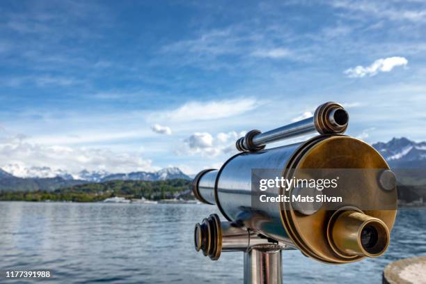 telescope over alpine lake and snow-capped mountain - teleskop stock-fotos und bilder
