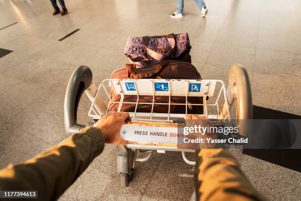 pov hand luggage cart - luggage trolley stockfoto's en -beelden