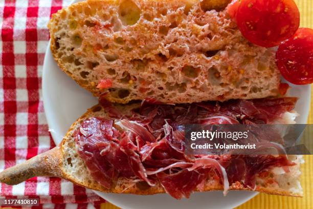 sandwich of bread with tomato, virgin olive oil and serrano ham breakfast - iberian stockfoto's en -beelden